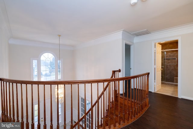corridor featuring a chandelier, wood finished floors, an upstairs landing, baseboards, and ornamental molding