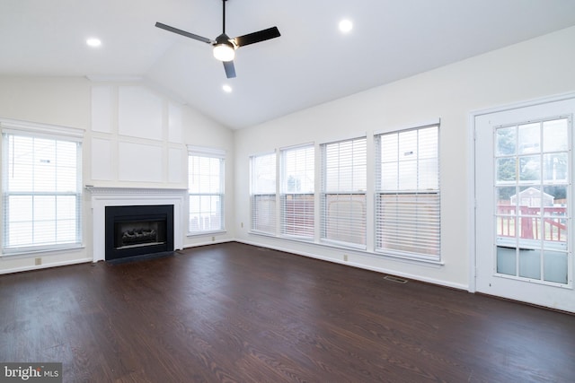 unfurnished living room featuring dark wood-style floors, lofted ceiling, and plenty of natural light
