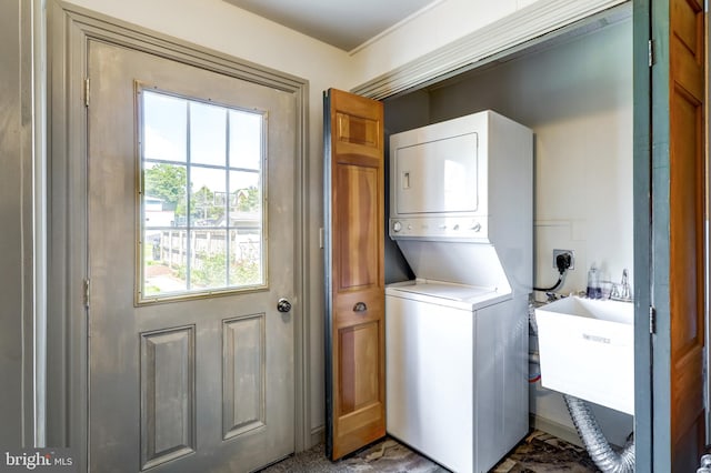 washroom with stacked washer / dryer and sink