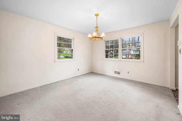 carpeted empty room featuring visible vents, baseboards, and an inviting chandelier