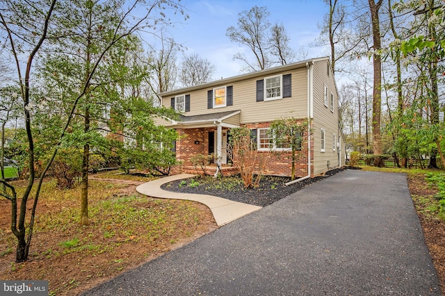 view of front of home featuring aphalt driveway and brick siding