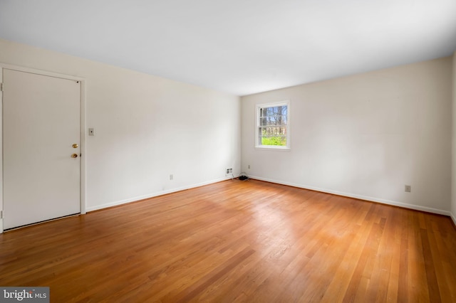 empty room featuring light wood-style flooring and baseboards