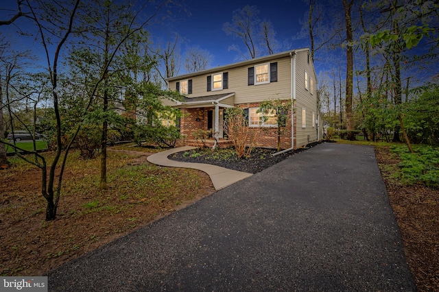 view of front facade with driveway and brick siding