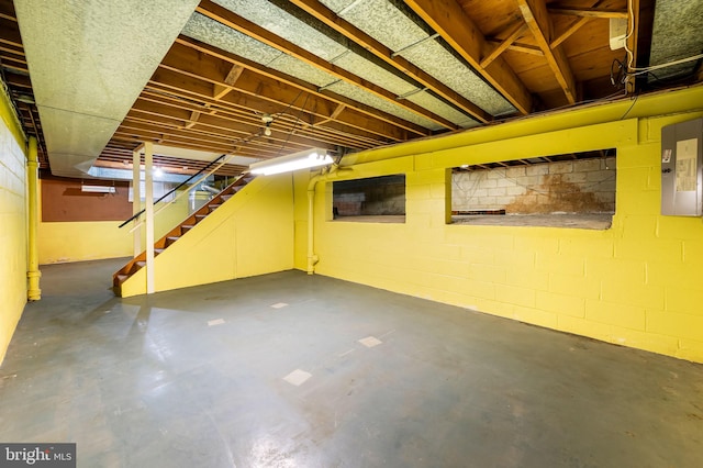 unfinished below grade area with electric panel and stairs