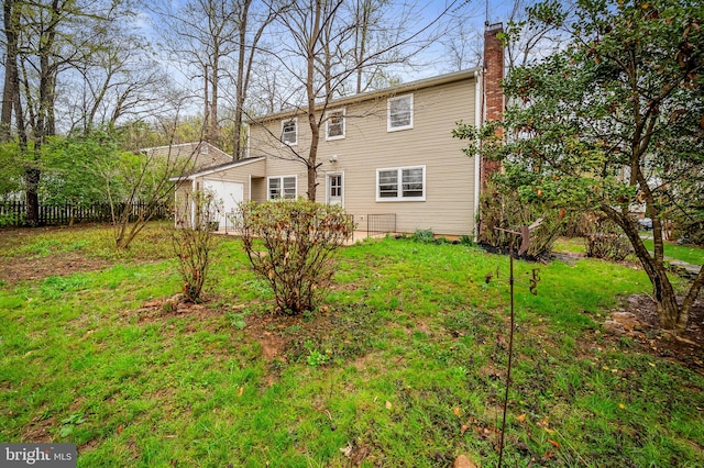 view of front facade featuring a chimney, a front yard, and fence