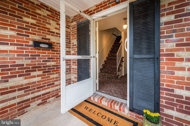 doorway to property featuring brick siding