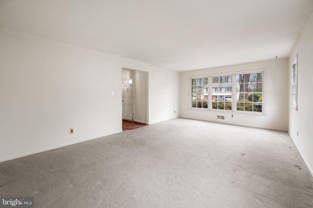 carpeted spare room with baseboards and visible vents