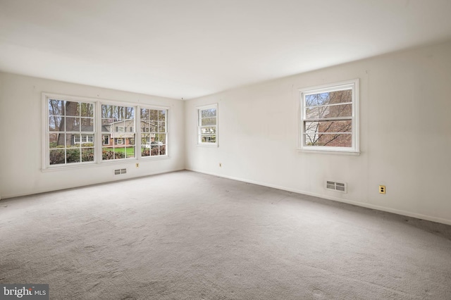 carpeted empty room with visible vents and baseboards
