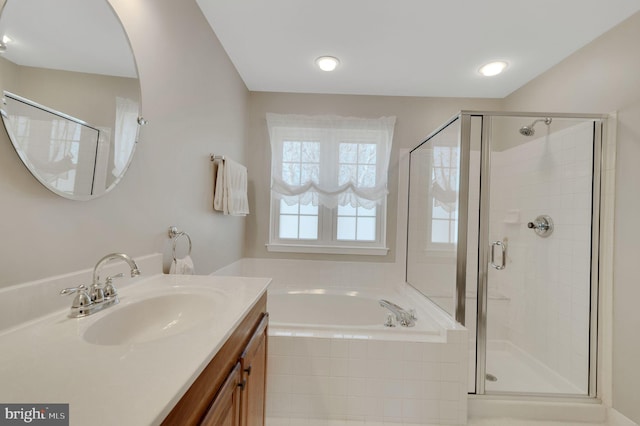 full bathroom featuring a stall shower, a garden tub, and vanity