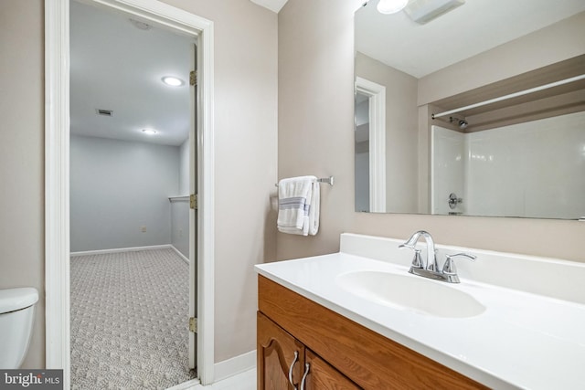 full bath featuring toilet, visible vents, vanity, baseboards, and walk in shower