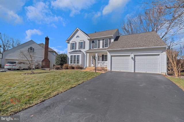 view of front of house featuring a shingled roof, covered porch, an attached garage, a front yard, and driveway