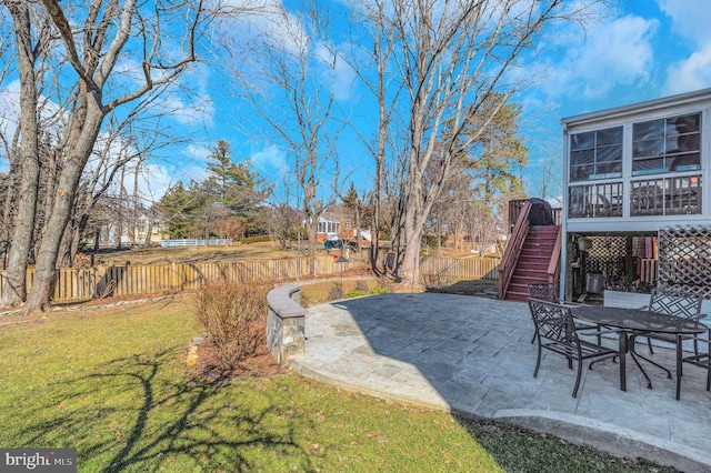 view of yard featuring stairs, a patio area, fence, and a sunroom