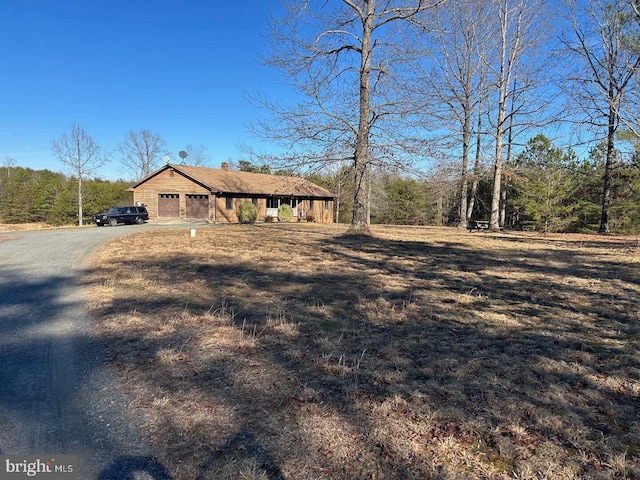 view of front of house with driveway, a chimney, and an attached garage