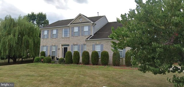 view of front of home featuring a front lawn and brick siding