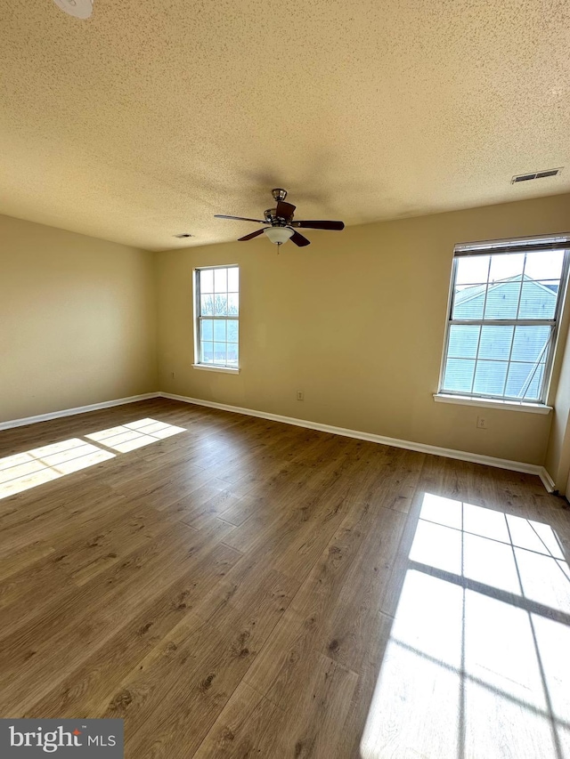 unfurnished room featuring wood-type flooring, ceiling fan, and a textured ceiling