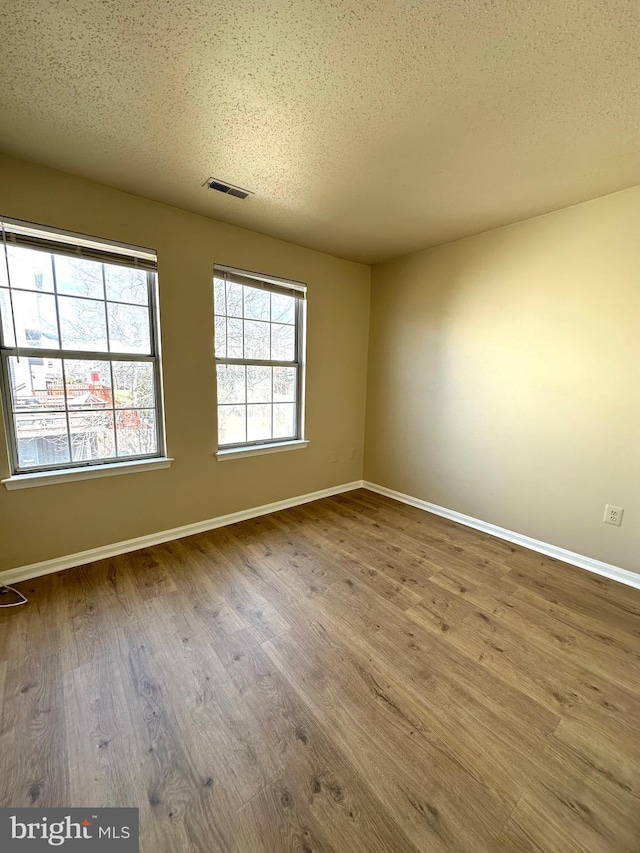 empty room featuring hardwood / wood-style floors and a textured ceiling