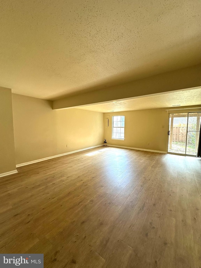 empty room with hardwood / wood-style flooring and a textured ceiling