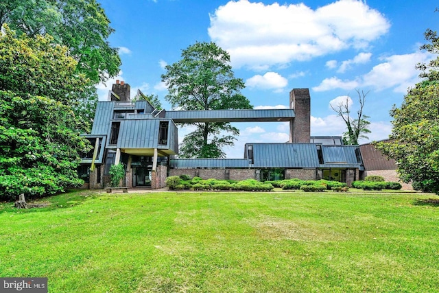 back of property featuring a chimney and a lawn