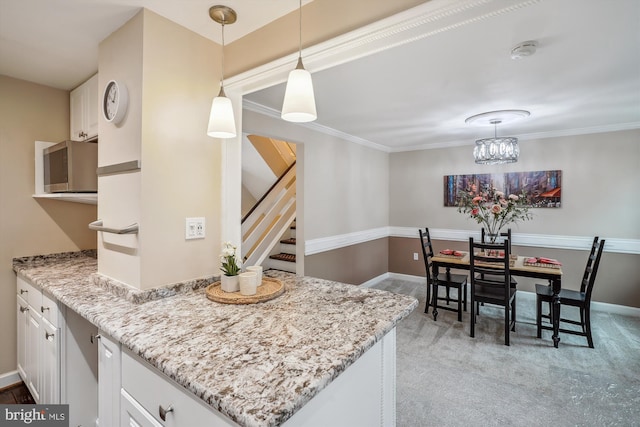 kitchen featuring light carpet, light stone countertops, white cabinetry, and crown molding