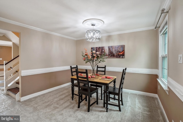 carpeted dining area featuring baseboards and crown molding