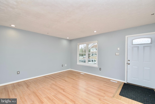 foyer featuring light hardwood / wood-style flooring and a textured ceiling