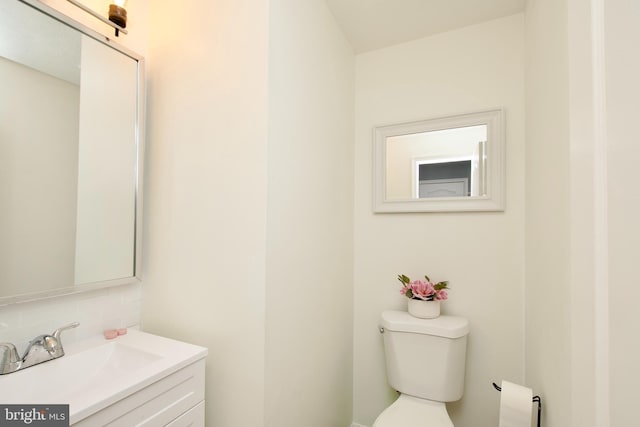 bathroom with toilet, backsplash, and vanity