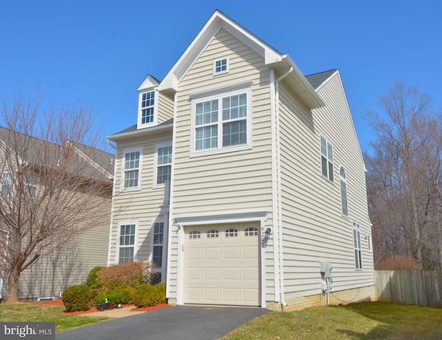 view of front of house featuring an attached garage, fence, and driveway