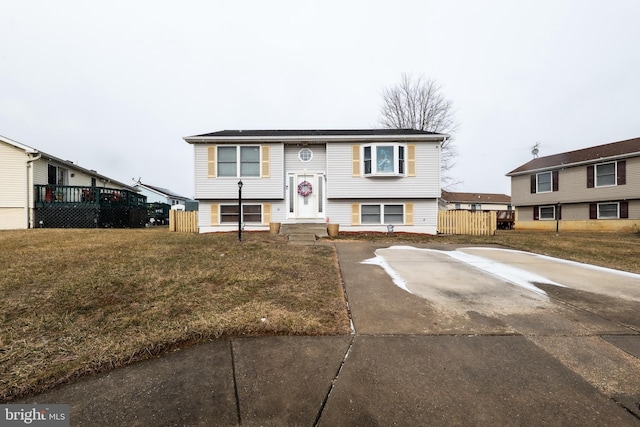 bi-level home featuring fence and a front lawn