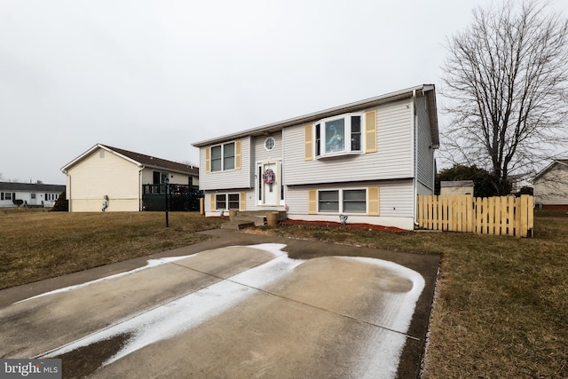 split foyer home with a front yard and fence