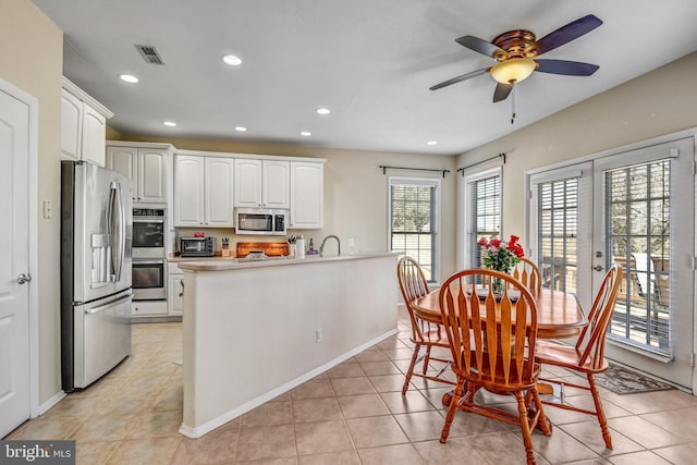 kitchen featuring visible vents, stainless steel appliances, light countertops, white cabinetry, and light tile patterned flooring