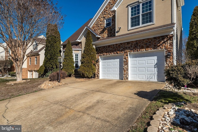 view of front facade with an attached garage, stone siding, concrete driveway, and stucco siding