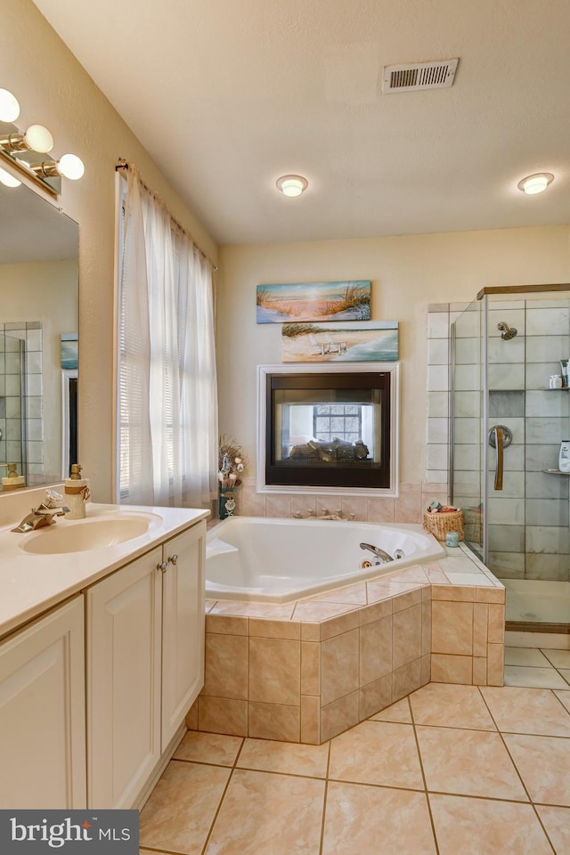 full bathroom with vanity, a stall shower, tile patterned flooring, and visible vents