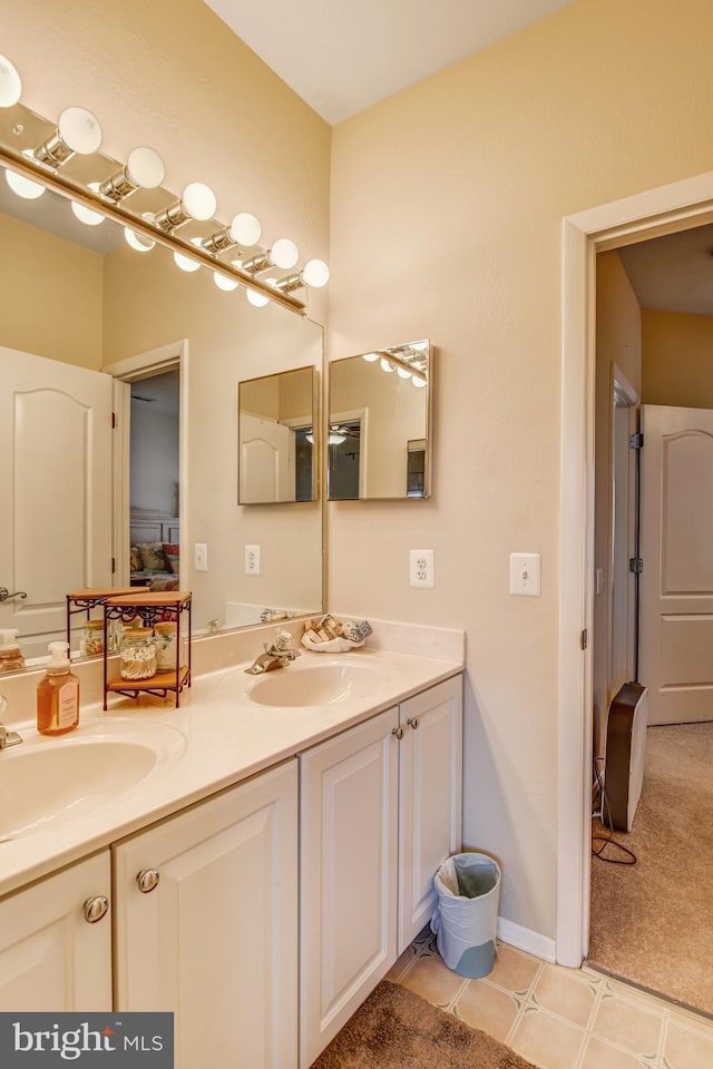 bathroom with a sink, baseboards, and double vanity