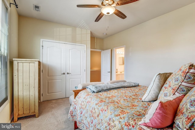 bedroom with visible vents, light colored carpet, ceiling fan, vaulted ceiling, and a closet