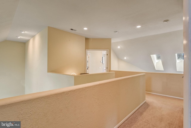 corridor with lofted ceiling, recessed lighting, visible vents, light carpet, and baseboards