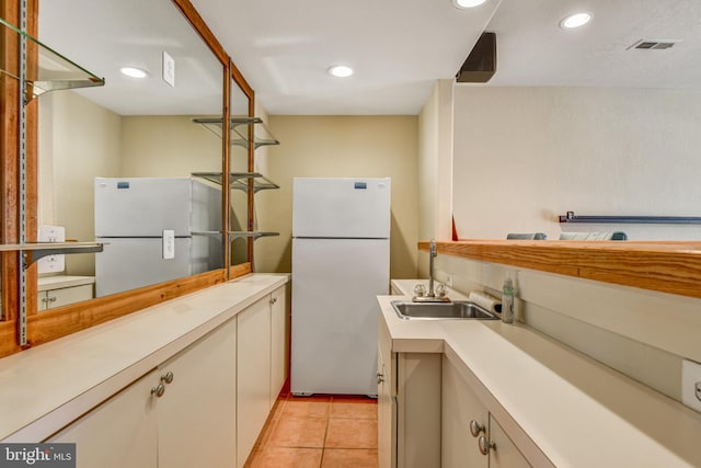 kitchen featuring light countertops, a sink, and freestanding refrigerator