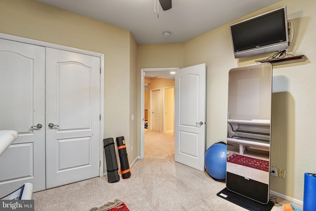 interior space with light carpet, ceiling fan, and baseboards