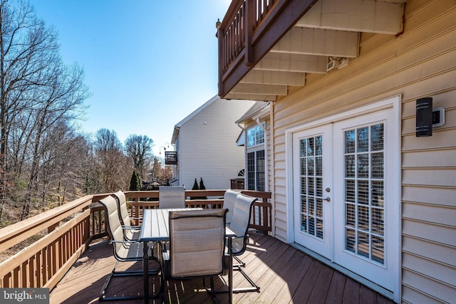 wooden deck featuring outdoor dining area and french doors