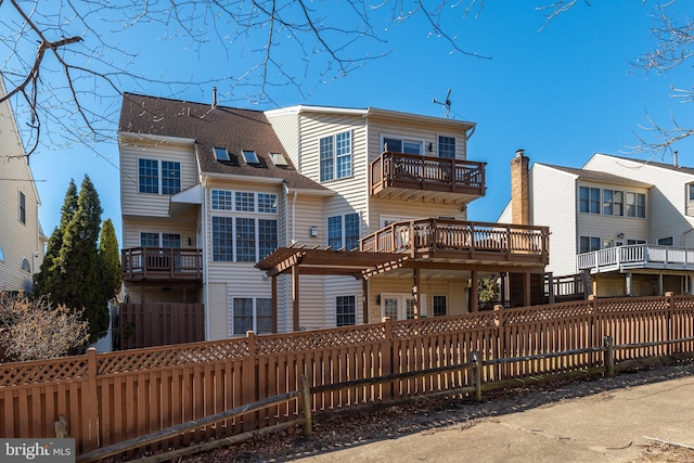 rear view of property featuring a fenced front yard and a pergola