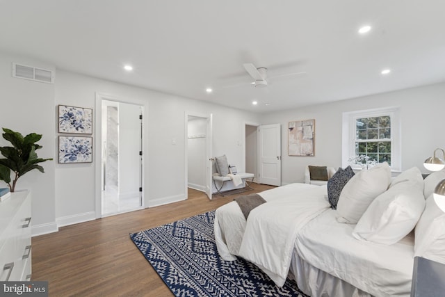 bedroom featuring ceiling fan, ensuite bathroom, a spacious closet, and hardwood / wood-style floors