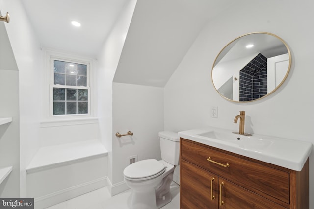 bathroom with lofted ceiling, vanity, and toilet