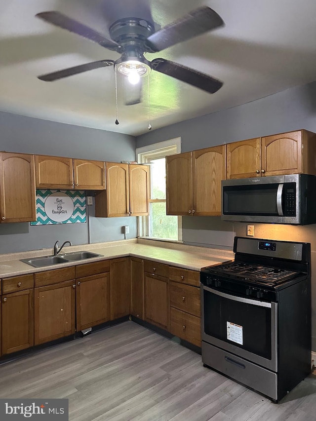 1428 W State St, Trenton, NJ 08618 - kitchen with stainless steel appliances, a ceiling fan, light countertops, light wood finished floors, and brown cabinets