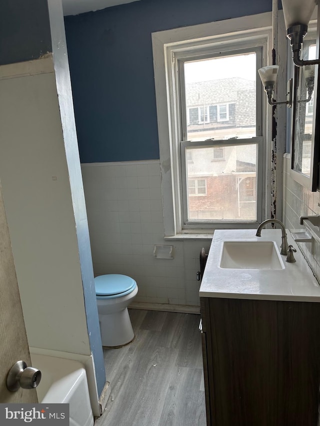 1428 W State St, Trenton, NJ 08618 - full bath with tile walls, wood finished floors, vanity, and wainscoting