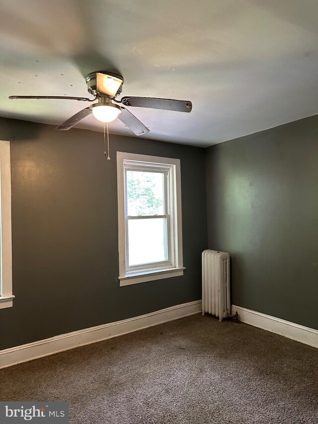 1428 W State St, Trenton, NJ 08618 - empty room featuring radiator heating unit, dark carpet, and ceiling fan