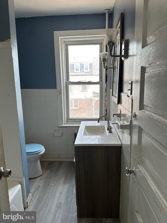 1428 W State St, Trenton, NJ 08618 - bathroom with tile walls, vanity, wood finished floors, and wainscoting