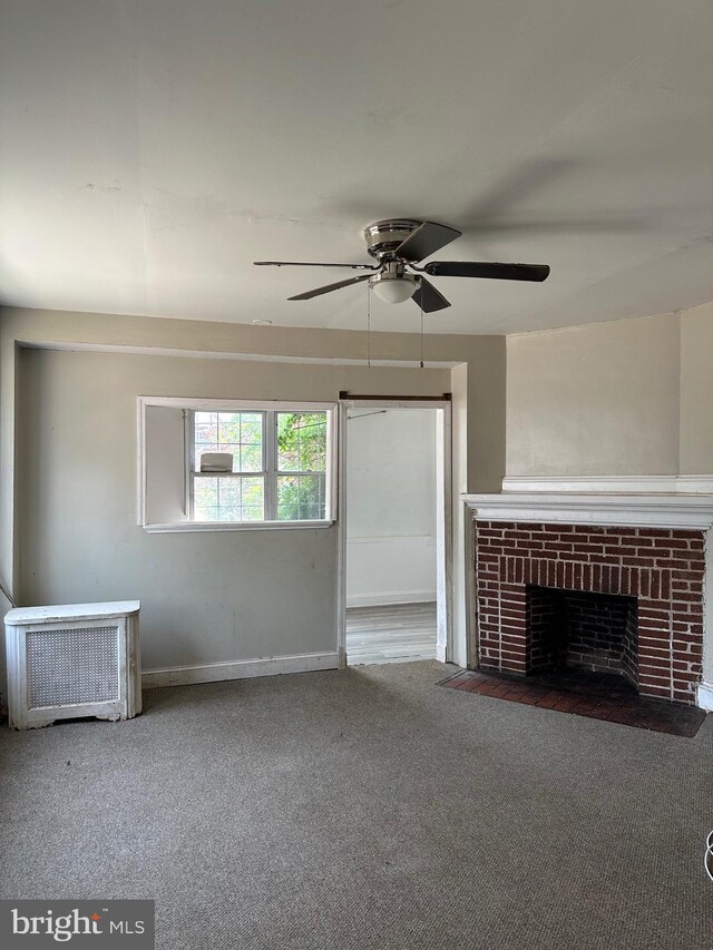 1428 W State St, Trenton, NJ 08618 - unfurnished living room featuring carpet floors, ceiling fan, and a brick fireplace