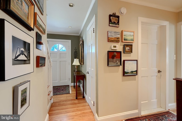 interior space with ornamental molding, baseboards, and light wood finished floors