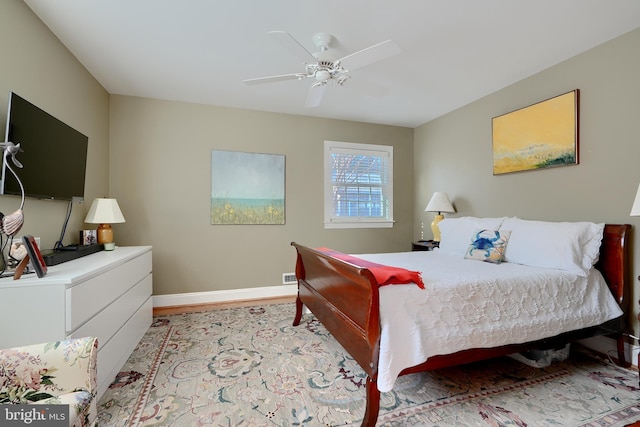 bedroom featuring a ceiling fan, light wood-style floors, and baseboards