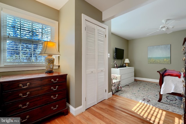 bedroom featuring light wood-type flooring, a closet, and baseboards