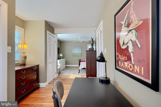 corridor with light wood-style flooring and baseboards